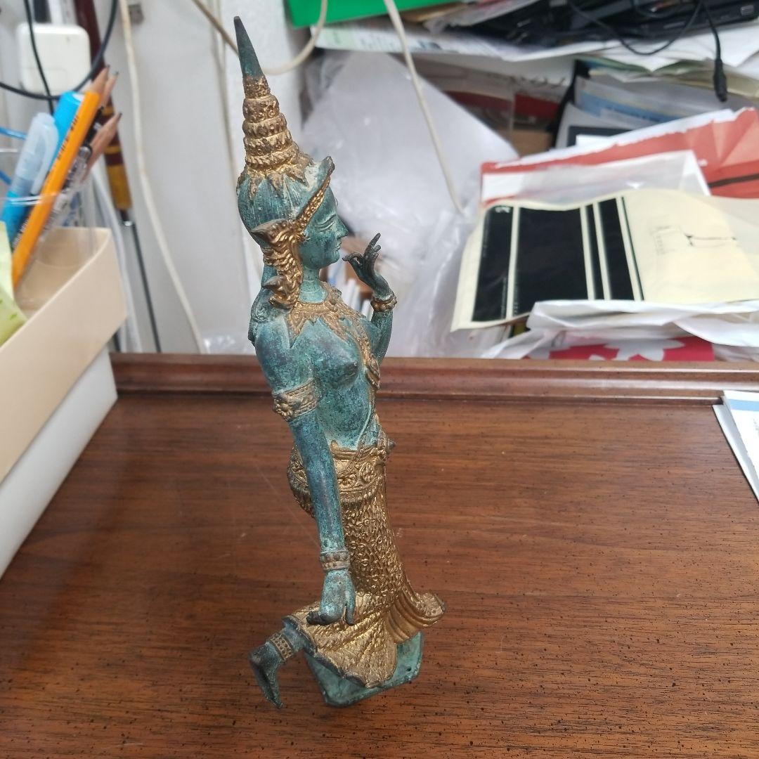 青銅色と金色のアジアの立像