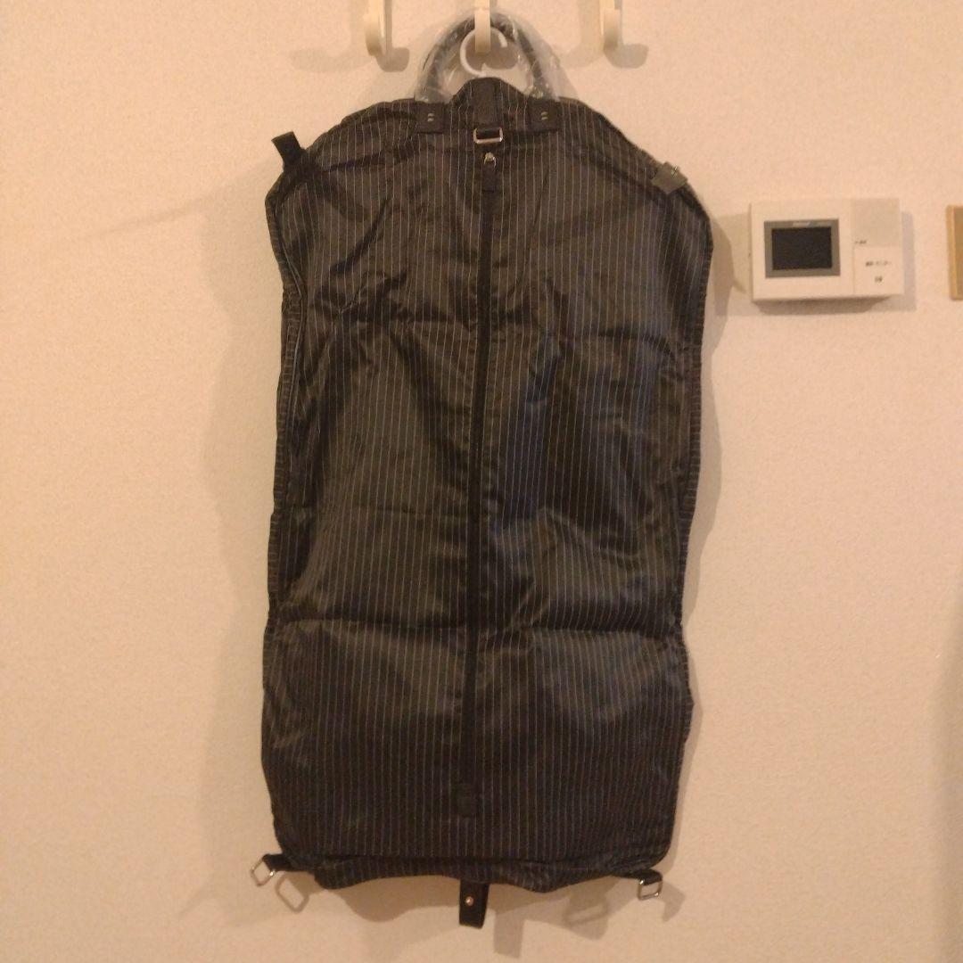 ZEGNA ストライプデザインの黒色ガーメントケース、レザー製ハンドル付き。