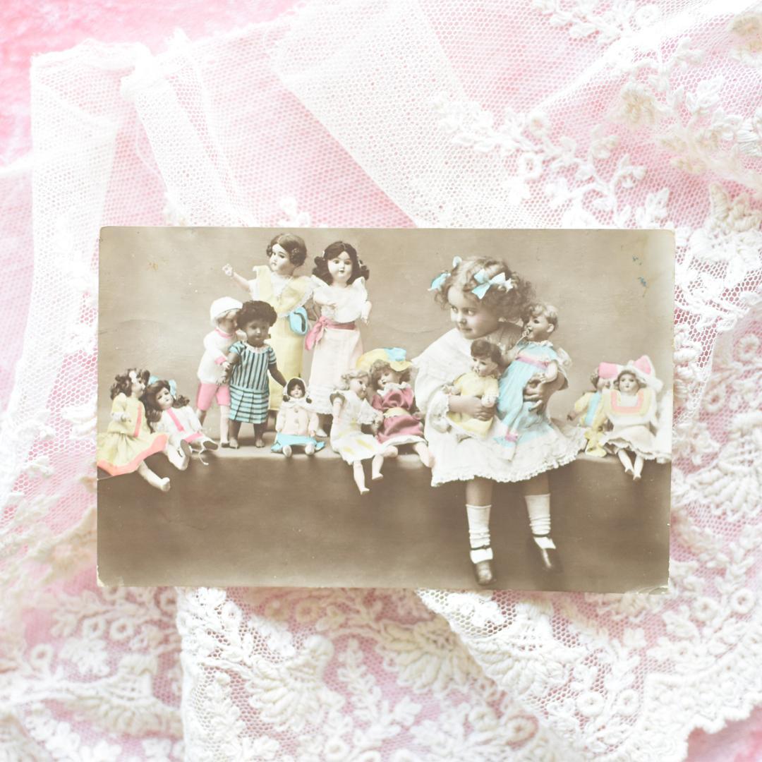 *アンティークポストカード　たくさんのお人形と愛らしい少女