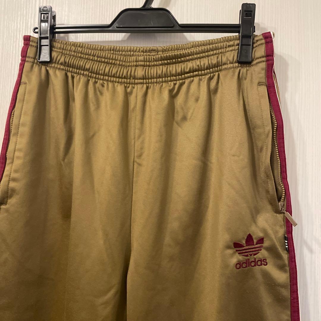 アディダスオリジナルス　adidas 国旗タグ３本ライントラックパンツ　ゴールド