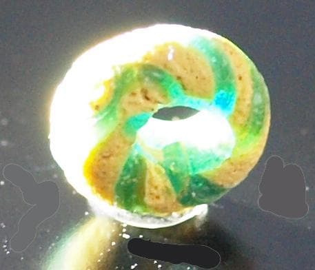 クリアな青緑に鮮やか黄で、回転する輪状モチーフを描くモザイク平玉　前後～6C頃の