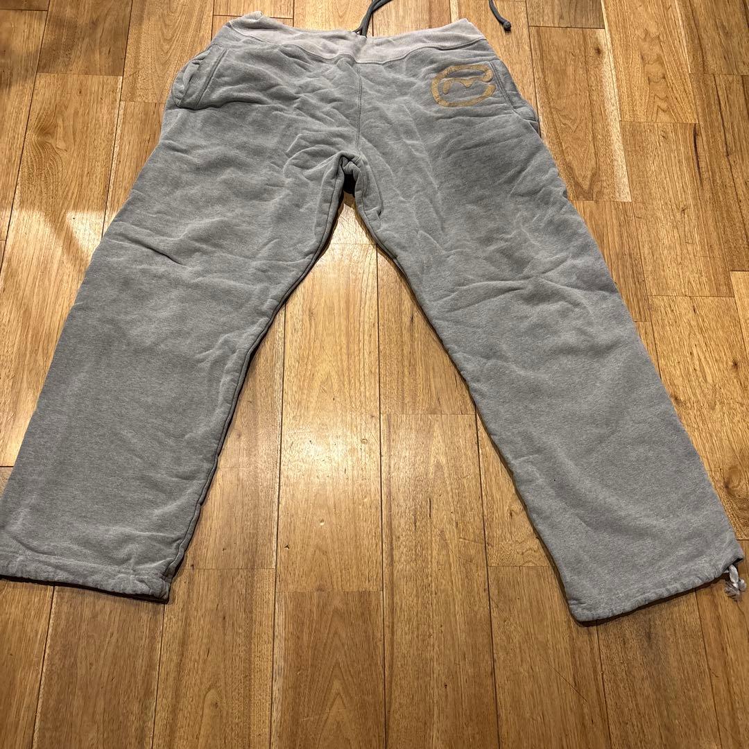 グレー スウェットパンツ 赤いパッチ 金色ロゴ