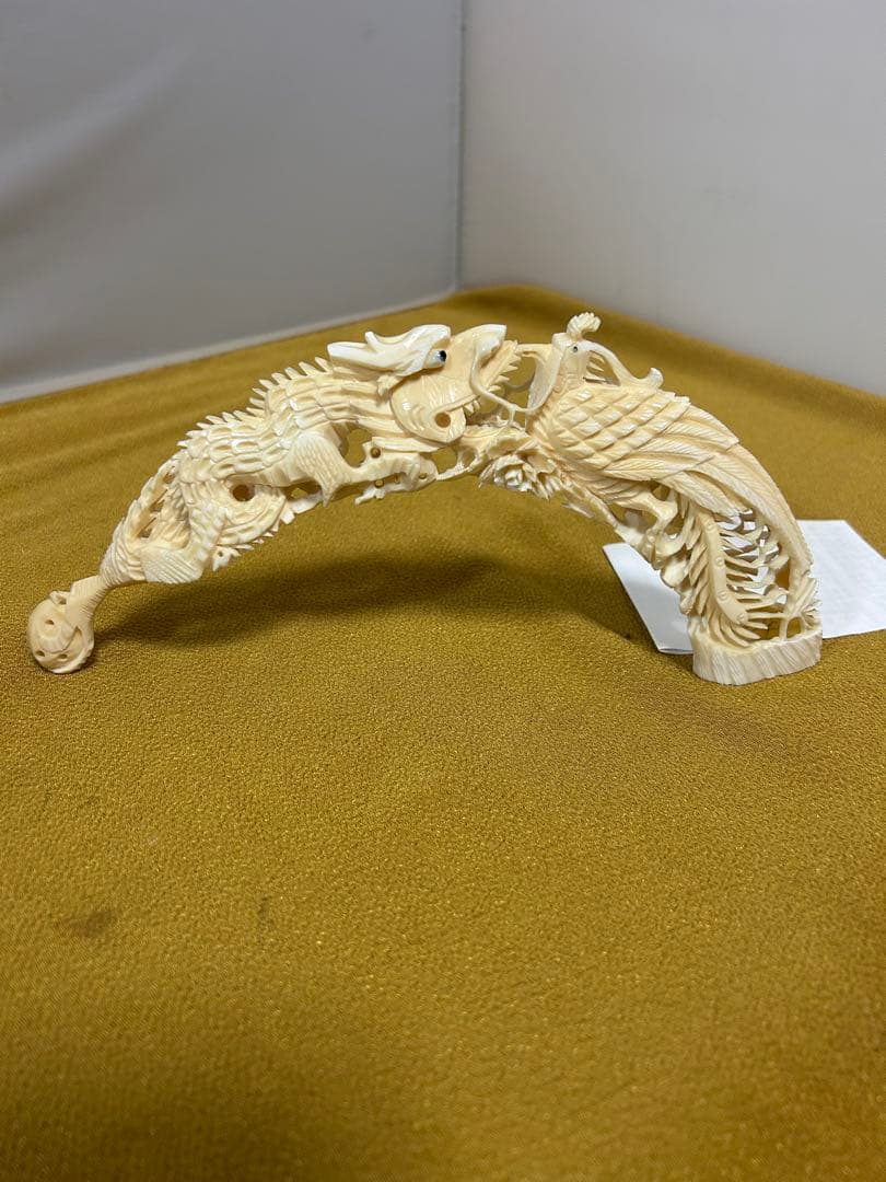 マンモスの牙や天然素材から彫られた、龍や鳳凰の精巧な透かし彫りが施された彫刻品