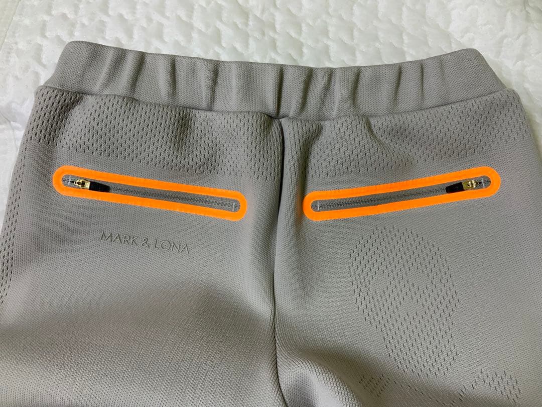マークアンドロナレディースパンツ オレンジジッパー