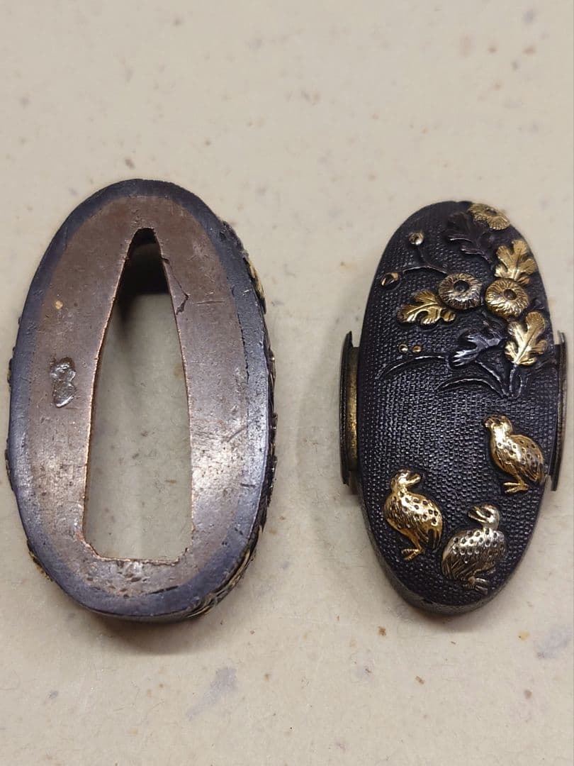 縁頭、赤銅魚子地に秋草に鶉図