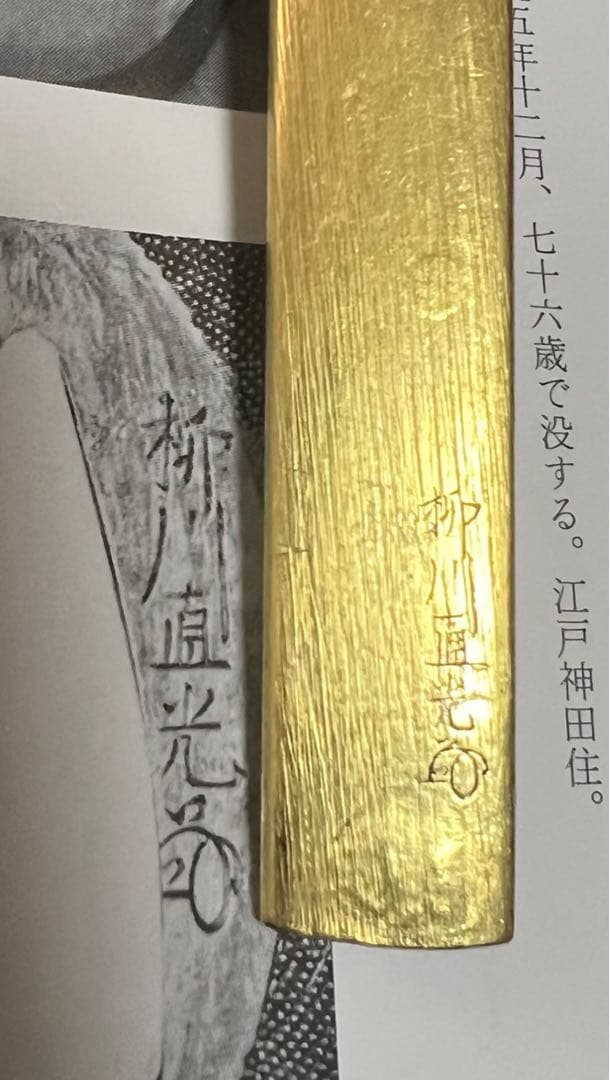 赤銅魚子地据紋哺金獅子図小柄 銘　柳川直光(花押)