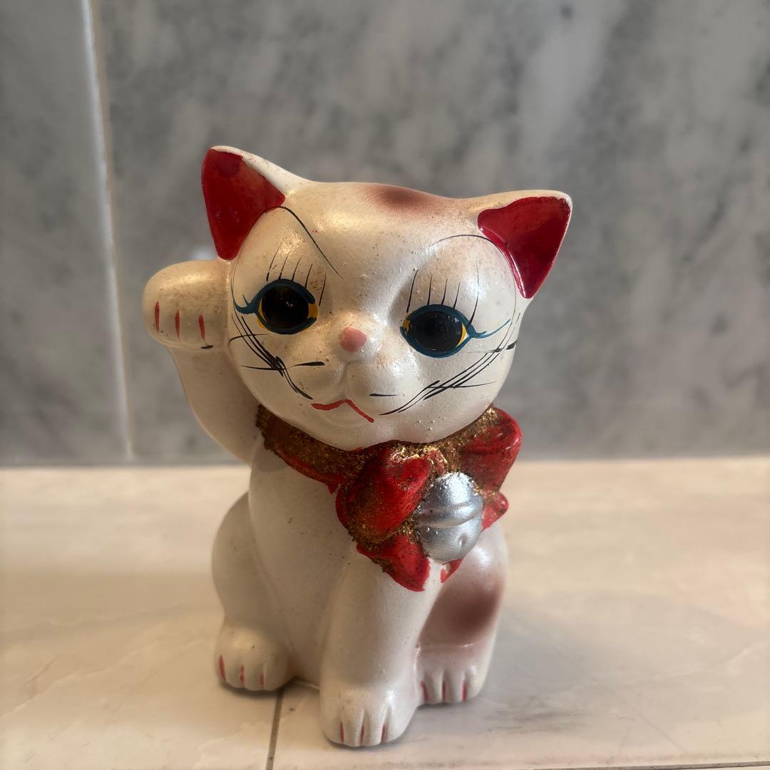 アンティーク大きな瞳や長いヒゲ、まつ毛が美しく、大きなリボンも可愛い招き猫