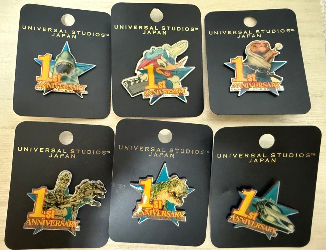 USJ1周年記念ピンバッチ7種とピントレ記念ピンバッチ付きコレクションポード