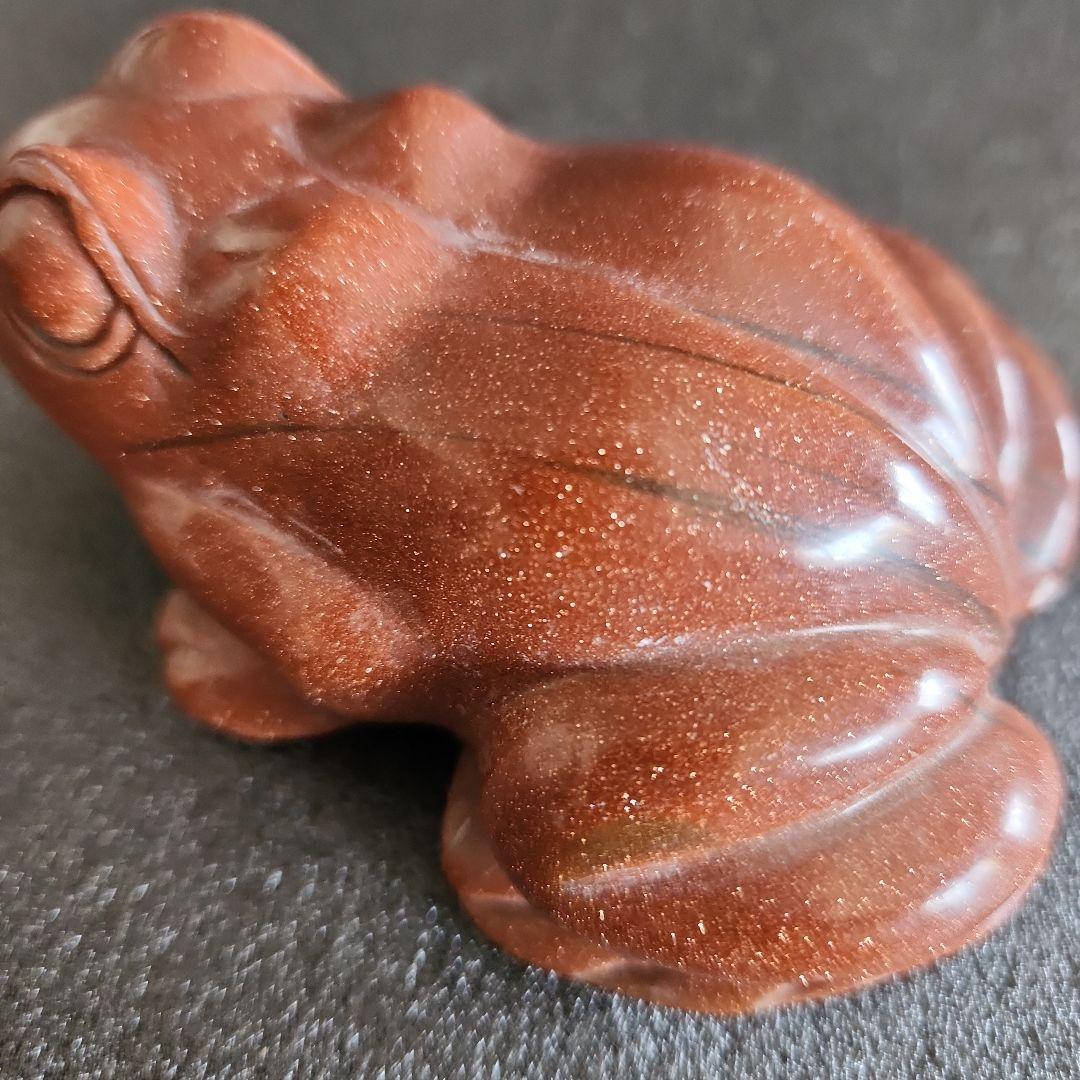 金色の光沢のあるブラウンカエルの石彫刻