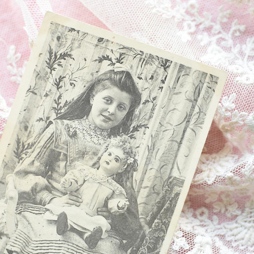 *アンティークポストカード　お人形と素敵な新年を迎える可愛い少女